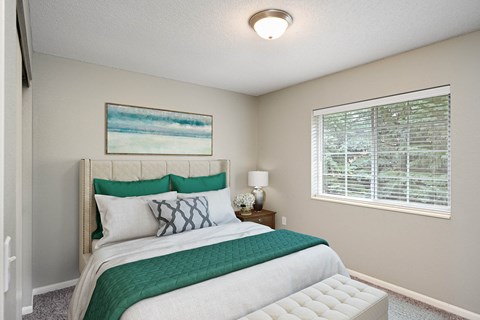 A bedroom with a large bed and a painting on the wall.