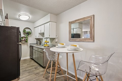 A kitchen with a table and chairs.