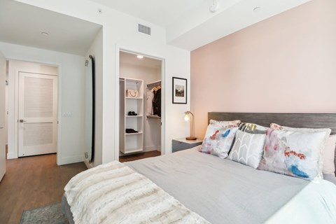 A bedroom with a large bed and a walk-in closet.