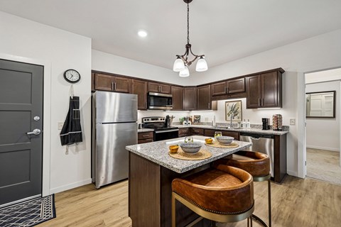 A kitchen with a table and chairs in the middle.