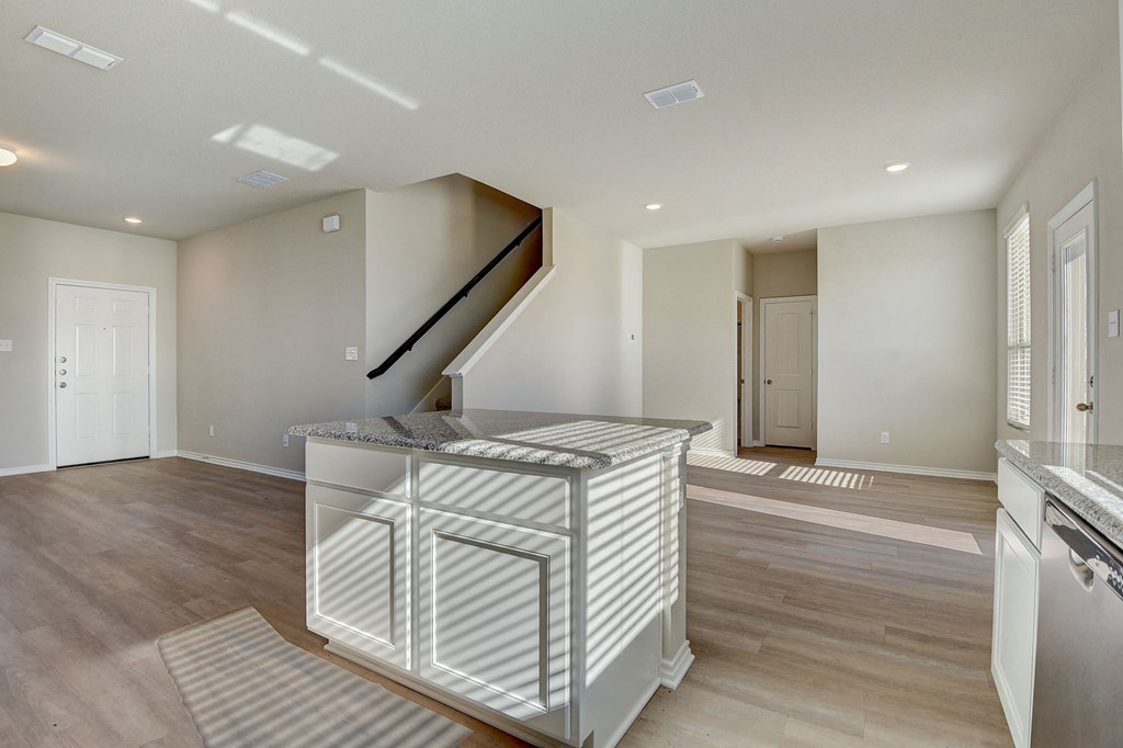 a kitchen island in a new home with a staircase