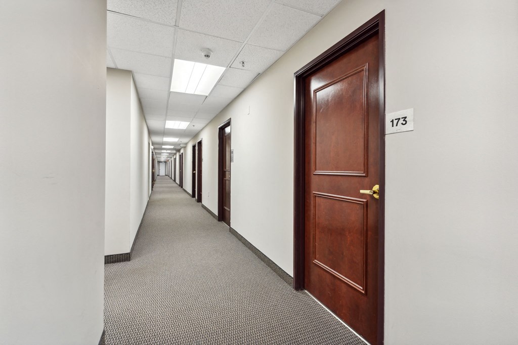 a row of doors in an empty office hallway