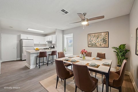 A dining room with brown chairs and a white table.