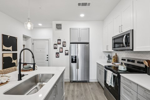 A modern kitchen with a stainless steel refrigerator and black oven.
