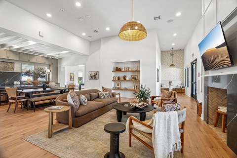A modern living room with a large couch, a coffee table, and a fireplace.