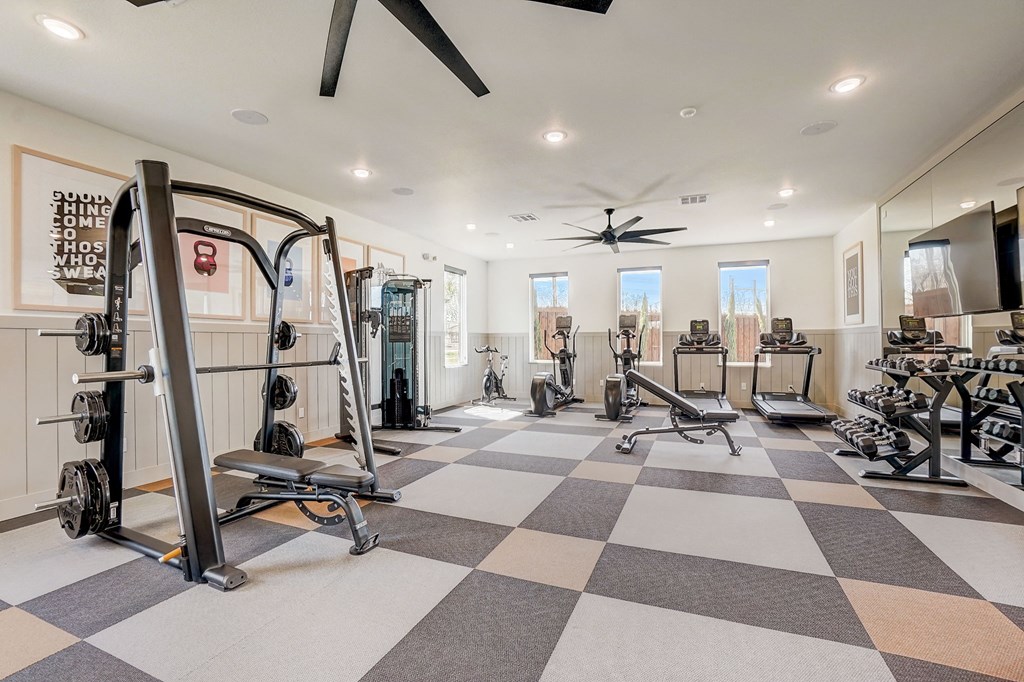 a home gym with exercise equipment and a ceiling fan