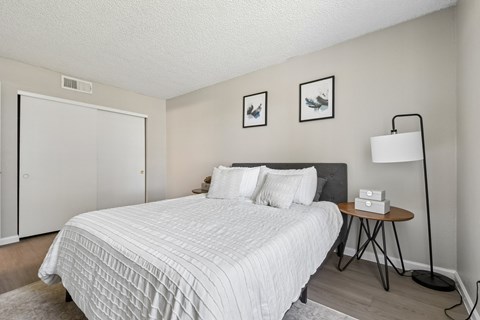 A bedroom with a white bed and a black headboard.