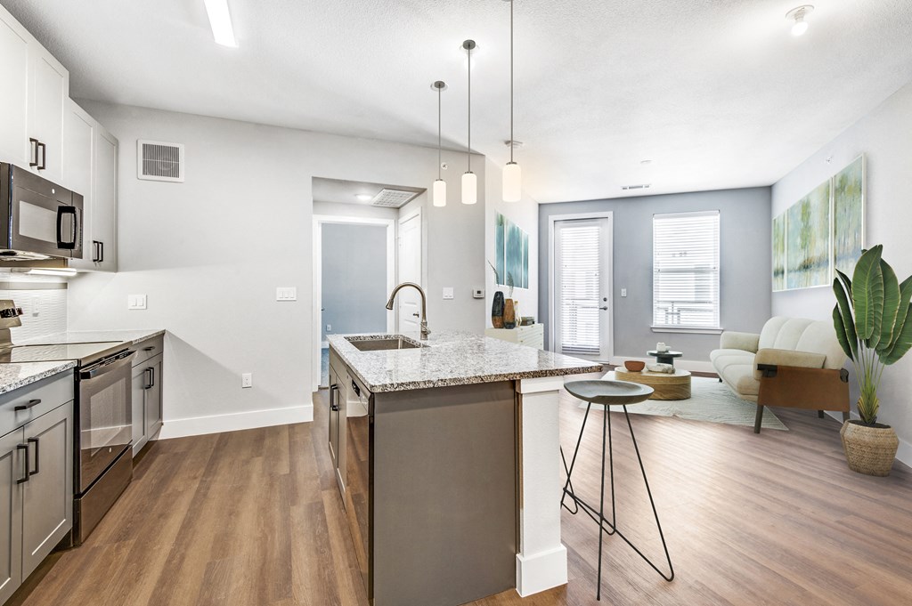 a kitchen with an island and a living room with a couch