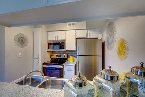 a kitchen with a stainless steel refrigerator and a sink