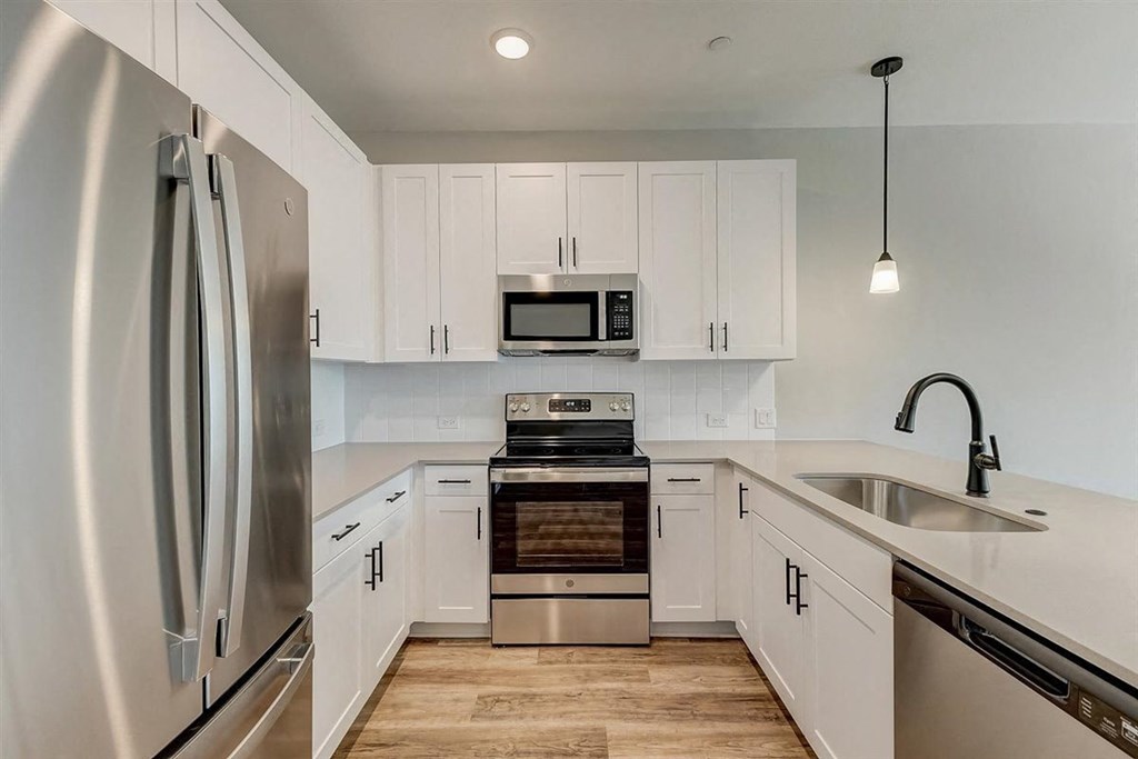a kitchen with white cabinets and stainless steel appliances