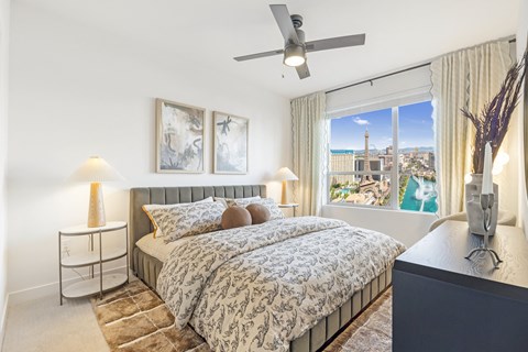A bedroom with a large bed and a view of the city.