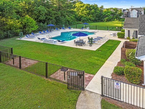 A backyard with a pool and a fence.