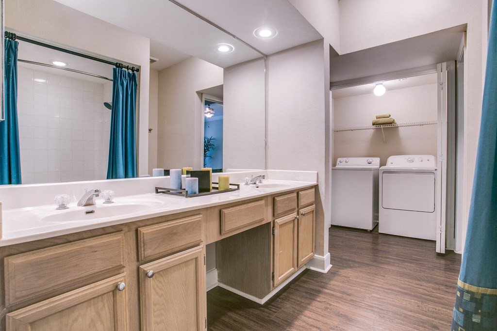 a bathroom with two sinks and a mirror and a laundry room