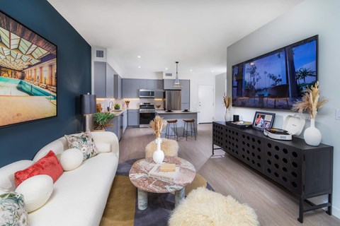 A modern living room with a white sofa and a coffee table.