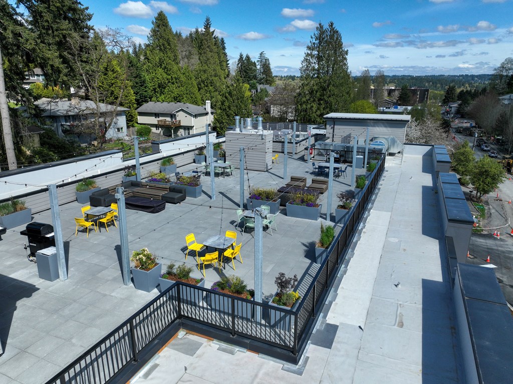 arial view of a rooftop patio with yellow tables and benches
