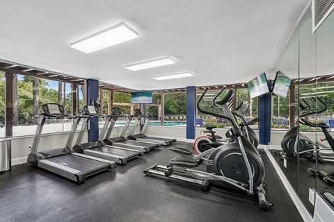 A gym with treadmills and elliptical machines.