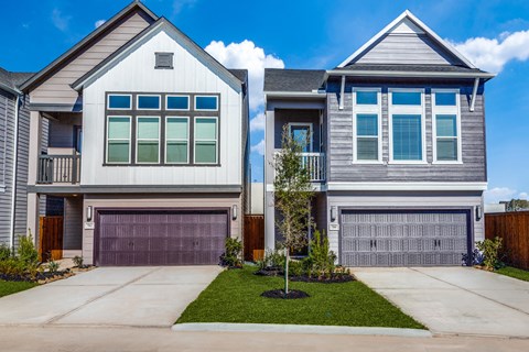 a house with two garage doors and a yard