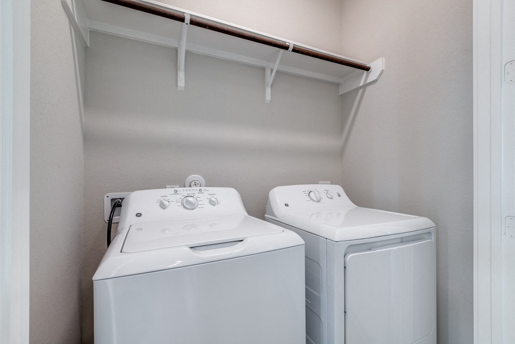an empty laundry room with two washes and a dryer