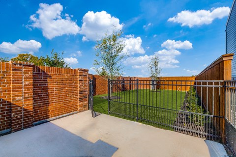 Two-Bedroom Homes for Rent in Houston, TX - East Heights - Dog Park with Green Grass, Trees, and Gated Fence.
