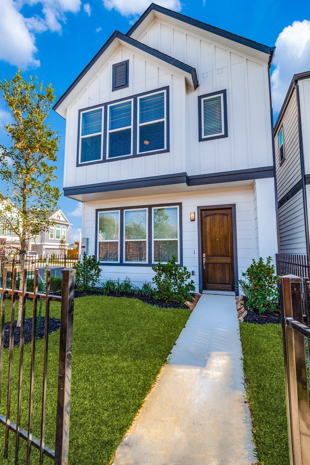 a white house with a wooden door and a sidewalk in front of it