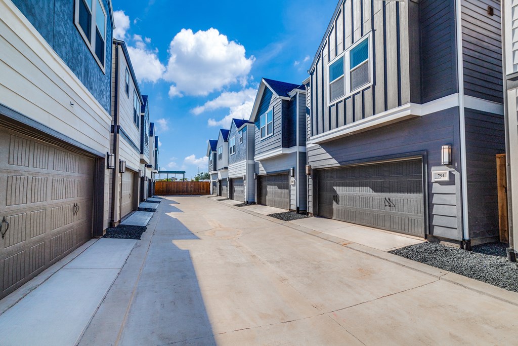 a row of buildings with garages on the side of a street