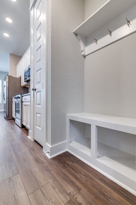 a renovated kitchen with white cabinets and a wood floor