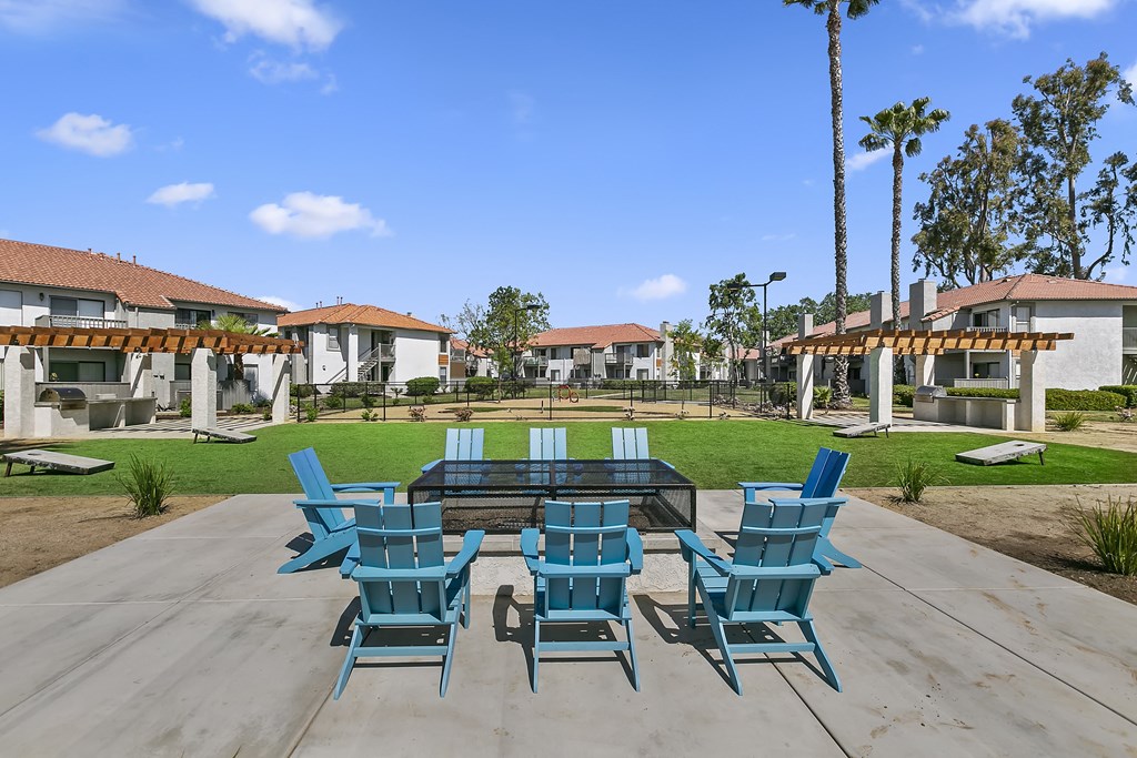 Apartments for Rent Moreno Valley - Ardella on Chagall - BBQ Area with Grilling Stations Under Pergolas, Manicured Grass Lawn, Cornhole Boards, Table and Chairs