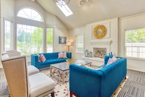 a living room with blue couches and chairs and a fireplace