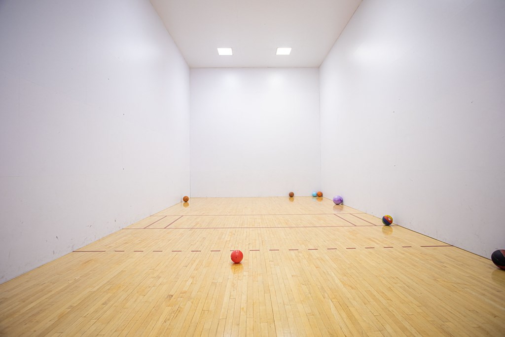 3-Bedroom Apartments in Puyallup, WA - One Canyon Place - Racquetball Court with White Walls, High Ceilings, and Equipment.