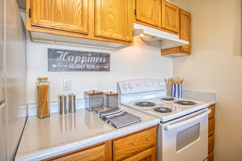 the kitchen has white appliances and wood cabinets