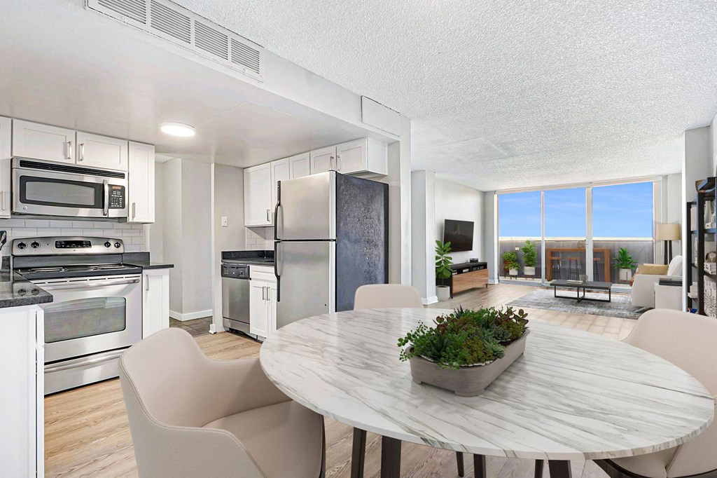a kitchen with stainless steel appliances and a marble dining table