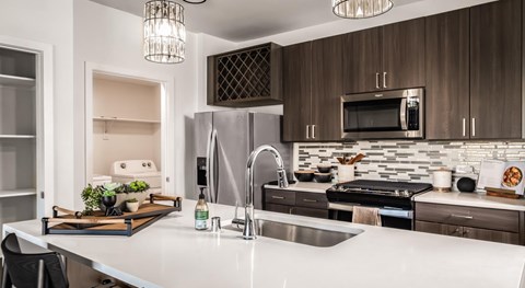 A modern kitchen with dark wood cabinets and white countertops.