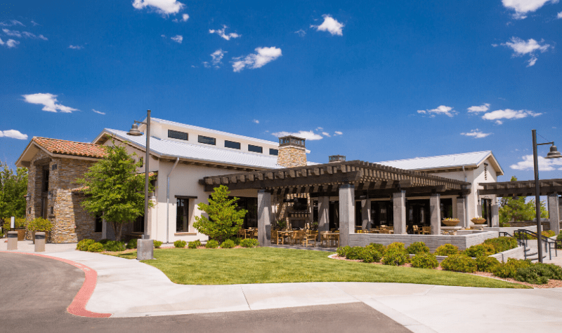 the front of a building with a lawn and a blue sky