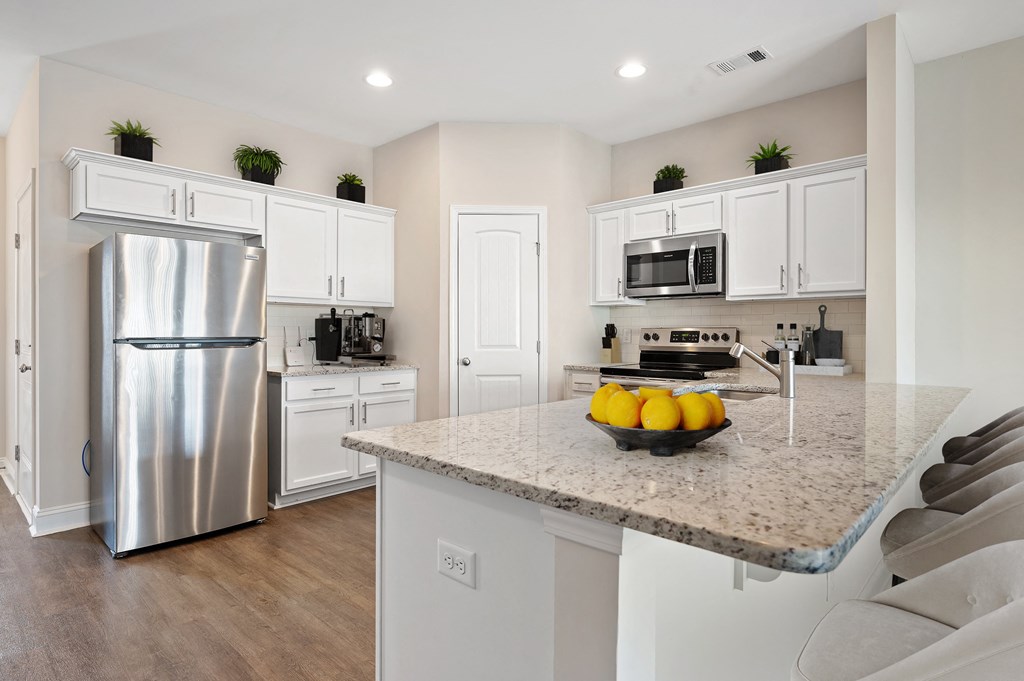 Omnia at Richmond Hill Townhomes in Georgia photo of a kitchen with stainless steel appliances and a granite counter top