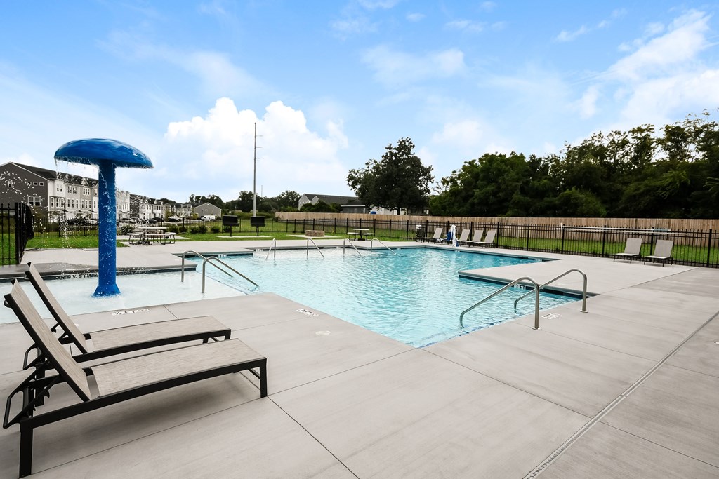 A pool with a blue umbrella and a sun lounger.