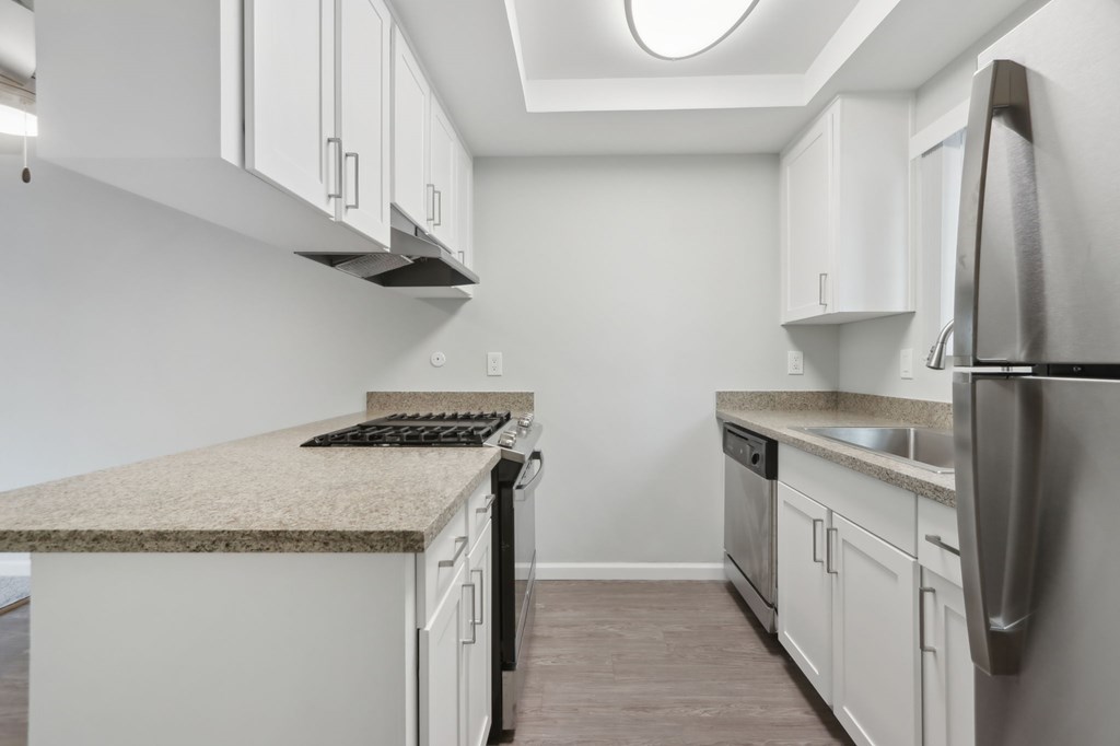 A kitchen with a granite countertop and stainless steel appliances.