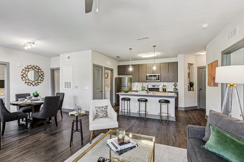 Spacious open-concept living room with view of modern kitchen and island at Lotus at Starkey Ranch in Odessa, Florida.