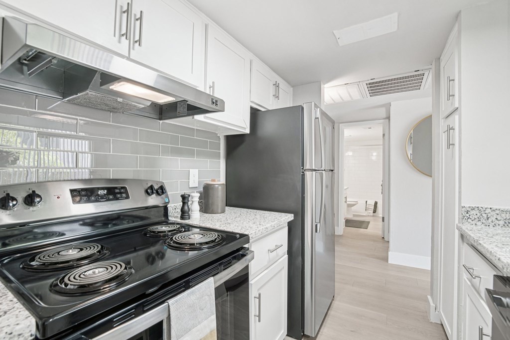 A kitchen with a black stove top oven and a black refrigerator.