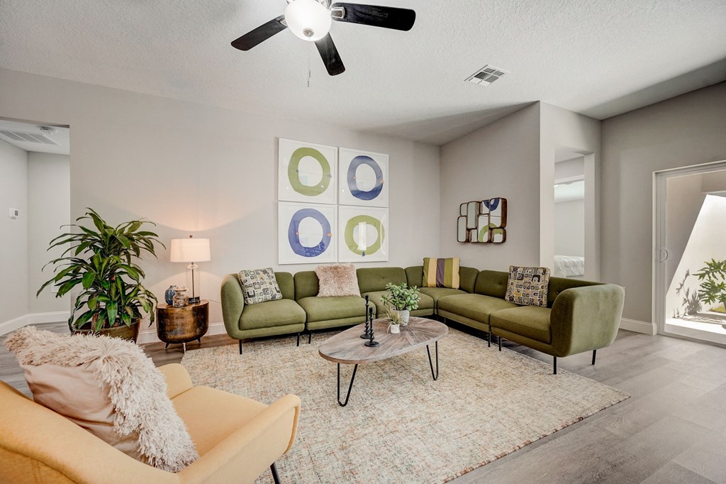 Large living room with a ceiling fan at The Groves at Lake Ella in Lady Lake, Florida, a pet-friendly rental community.