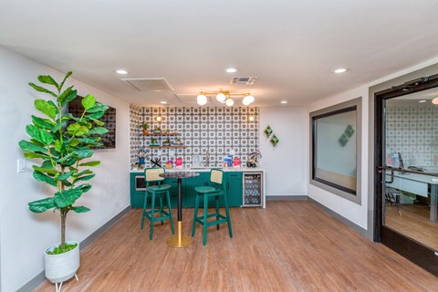 a dining room with a table and chairs and a kitchen with a plant