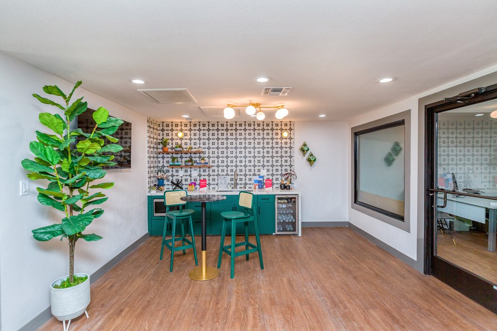 a dining room with a table and chairs and a kitchen with a plant