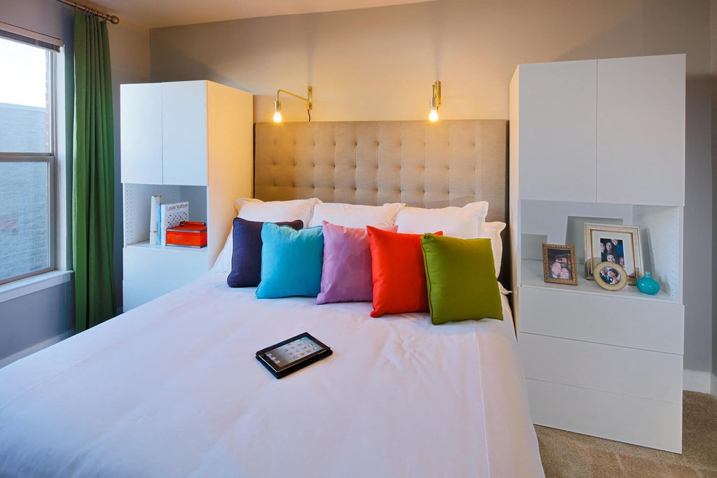 a bed with colorful pillows in a room