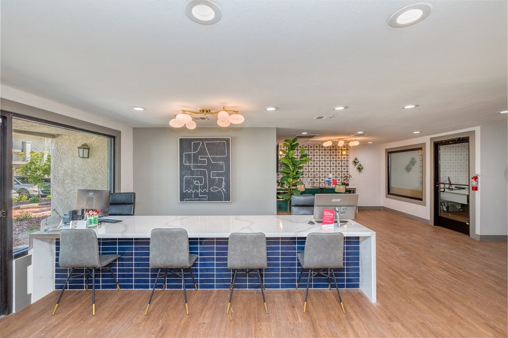 a conference room with a white counter and blue chairs