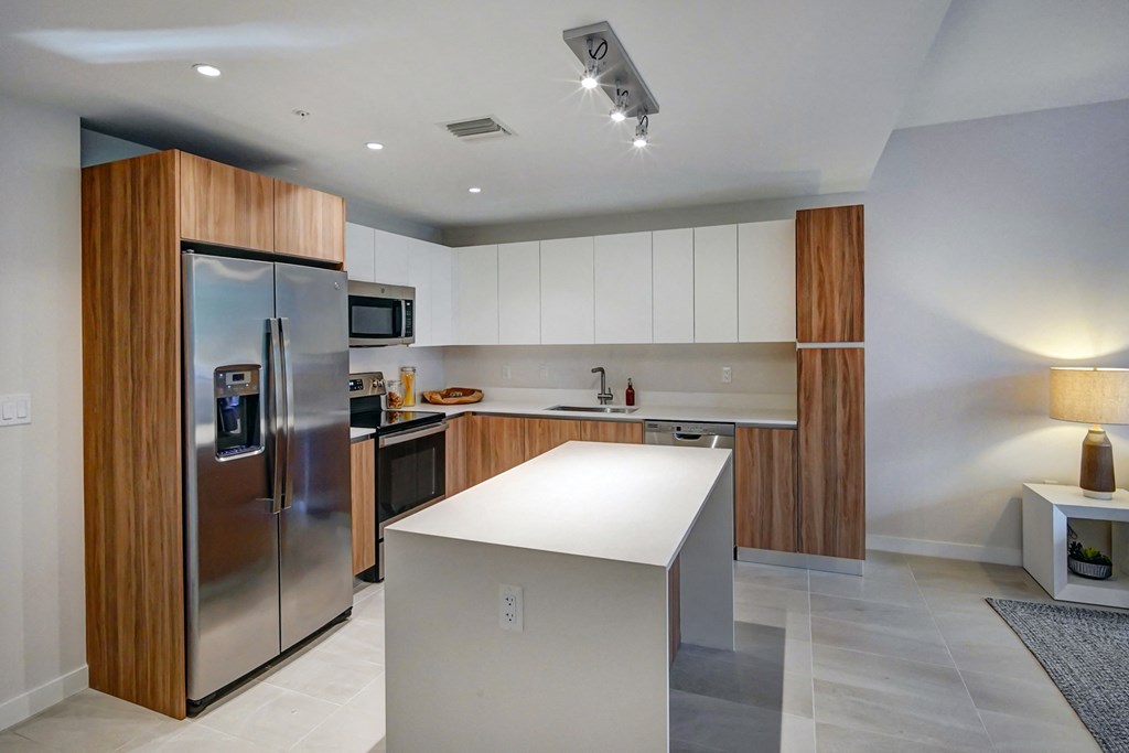 a modern kitchen with stainless steel appliances and a white island