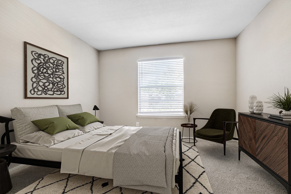 Apartments for Rent in Houston, TX 77036 – Artisan West – A bedroom with a bed, chair, and a plant.