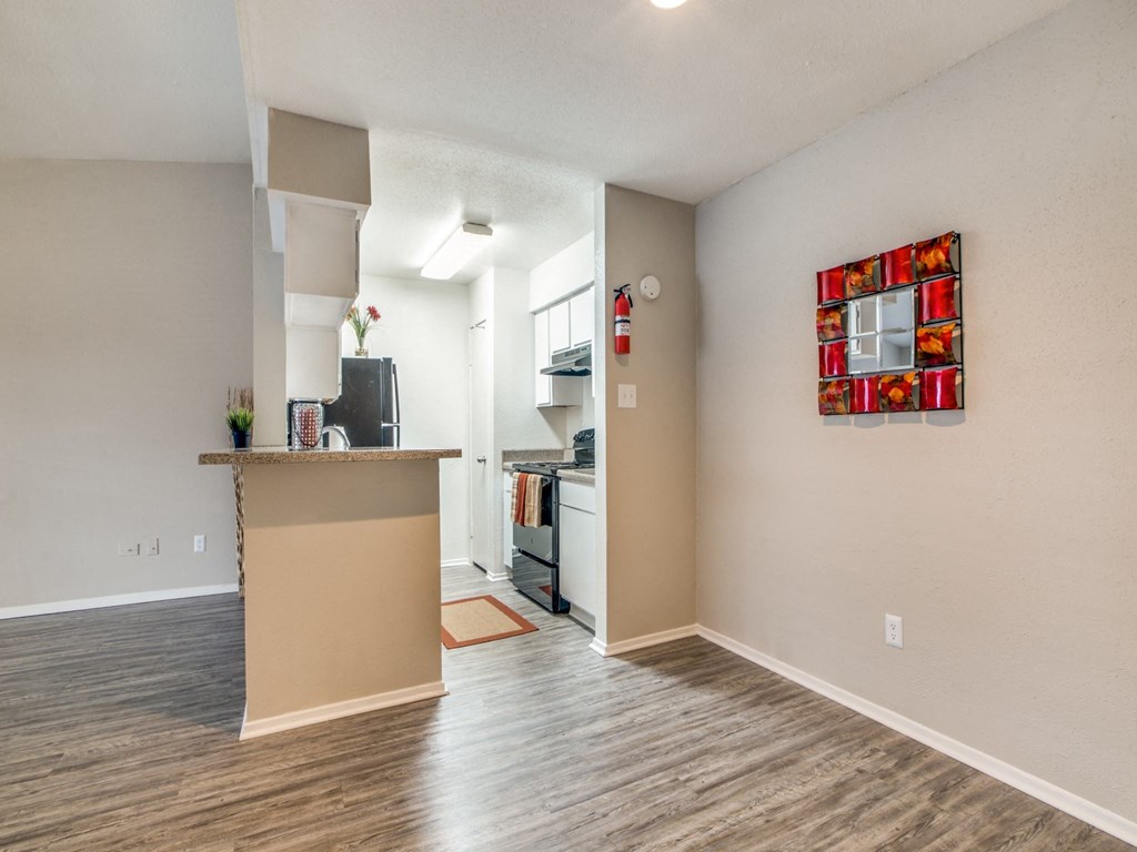 the living room and kitchen of an apartment with a counter top and a kitchen island