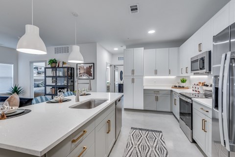 A modern kitchen with white cabinets and stainless steel appliances.