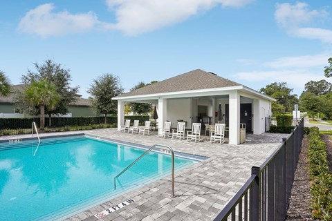 A pool with a house in the background.