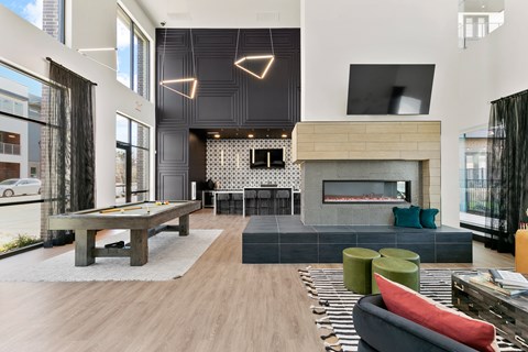 A modern living room with a pool table and a fireplace.