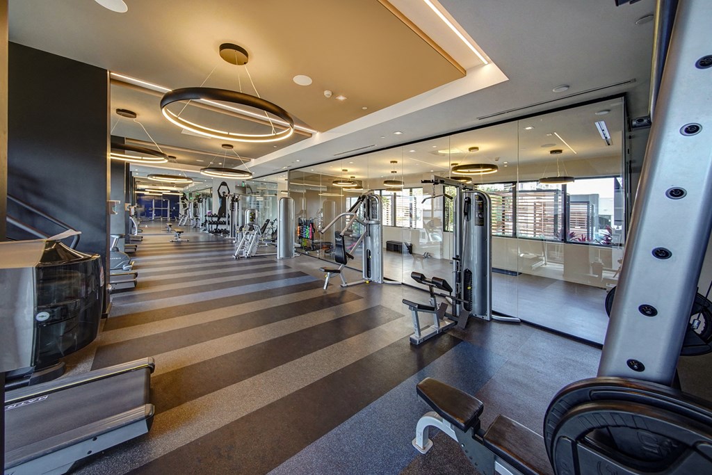 a gym with cardio machines and other equipment in a building